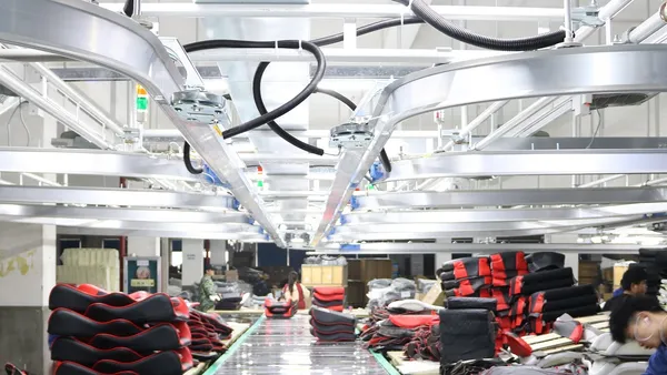 Upholstery production line at Global Furniture (Jiaruifu) — overhead conveyor and stacked seat cushions